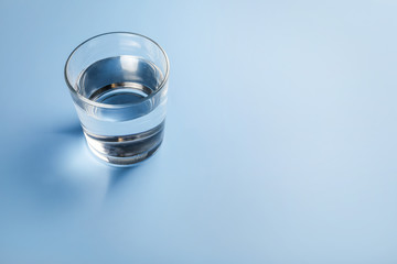 Wall Mural - Glass of water on blue background