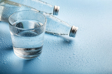 Wall Mural - Glass water bottles and glass of water on blue background