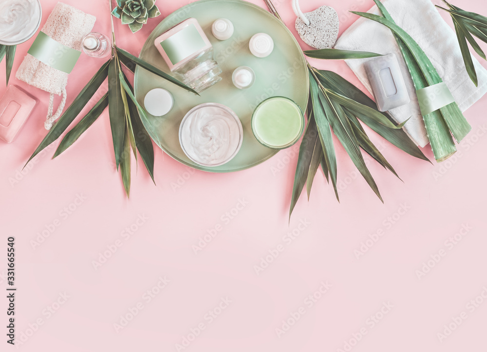 Modern beauty and skin care. Various natural cosmetic products with bamboo branches and aloe vera leaves. Eco friendly body care and spa accessories on pastel pink background. Zero waste . Top view - obrazy, fototapety, plakaty 