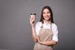 © LumenSt - Young woman in apron with coffee on  gray background. Barista concept