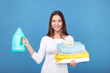 © LumenSt - Young woman in apron  on  blue background. Cleaning concept