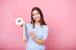 © LumenSt - Young woman holds toilet paper on  pink background.