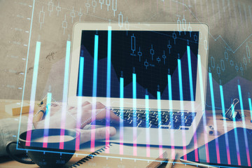 Forex graph with businessman working on computer in office on background. Concept of hardworking. Double exposure.