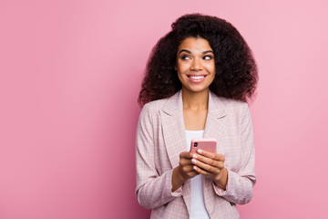 Wall Mural - Photo of beautiful funny positive dark skin lady hold telephone hands look side empty space have interesting idea creative person wear plaid blazer isolated pastel color background