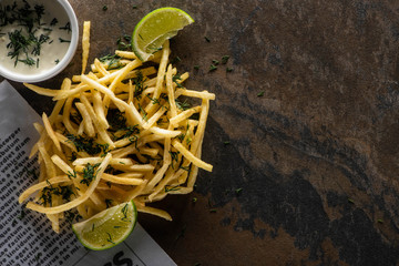 Canvas Print - top view of tasty french fries, lime and garlic sauce on marble surface