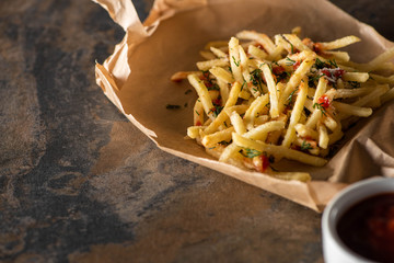 Sticker - tasty french fries on baking paper near ketchup on marble surface