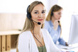 © rogerphoto - Portrait of call center operator at work. Group of people in a headset ready to help customers. Business concept