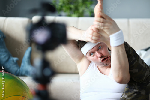 Cuadros en Lienzo Blogger Man with Funny Face Doing Exercise for Leg