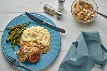 Sticker - Meat Burger with Mushroom Gravy, Smashed Potatoes and Green Beans on Wooden table. Top view, directly above.