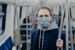 © VK Studio - Photo of male passenger wears face mask while travels by subway during infectious disease, prevents spreading coronavirus, poses in public transport, thinks about epidemic situation in his country