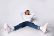 © FAB.1 - Teenager in sunglasses, jeans, sweater, socks and sneakers. Posing sitting on floor, legs wide apart, isolated on white. Close up