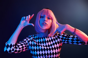 Wall Mural - Portrait of young girl with blond hair in red and blue neon in studio