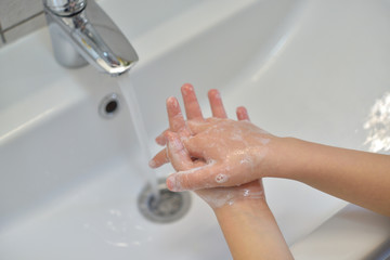 Close up of hands washing with soap. Washing hands with soap under the faucet with water. Clean and hygiene concept.