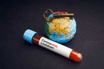 CORONAVIRUS LOCKDOWN text with world globe, key and Blood test vacuum tube on black background. Covid-19 or Coronavirus Concept