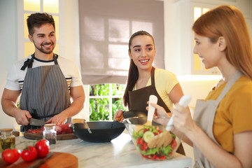 Wall Mural - Happy people cooking food together in kitchen