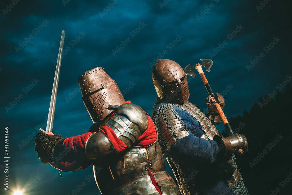 Two Medieval knights armed with axe and sword. - obrazy, fototapety, plakaty 