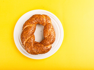 Turkish bagel on white plate with yellow background