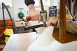 Making new upholstery. Woman work with pneumatic stapler in upholstery workshop.  Woman hands working.