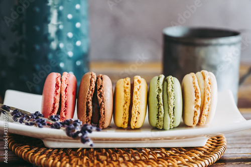 Assortiment de macarons colorés dans un plat en céramique Poster Mural XXL