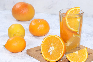 Citrus cider, juice, drink and ingredients on a concrete table. The concept of detox diet and weight loss, natural nutrition, increasing the body's immunity against viruses and colds