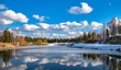 © Александр Овсянников - Spring landscape. Forest lake with reflection of clouds and trees growing along the shore, partially covered with ice and blue sky with clouds, at the beginning of a spring day.