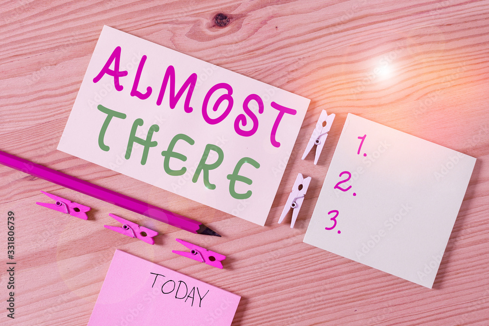 Writing note showing Almost There. Business concept for Soon to be or very nearly finished with some goal or task Colored clothespin papers empty reminder wooden floor background office