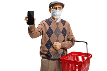 Poster - Elderly man with a medical face mask showing a mobile phone and carrying a shopping basket