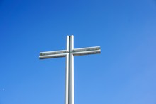 White Metal Cross With The Blue Sky In The Background