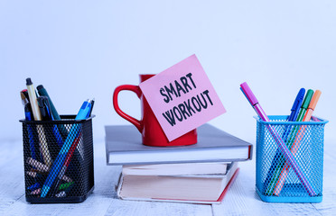 Poster - Word writing text Smart Workout. Business photo showcasing set a goal that maps out exactly what need to do in being fit Coffee cup blank sticky note stacked books pen metal holders wooden table