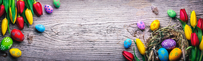 Canvas Print - Easter eggs and tulips on wooden planks