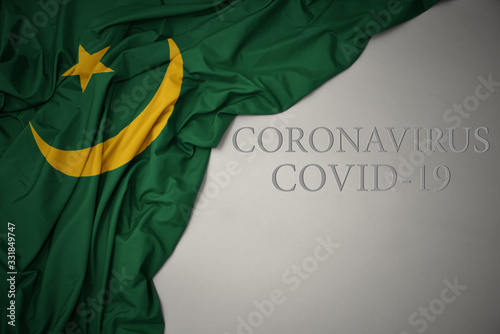 Cuadros en Lienzo waving national flag of mauritania on a gray background with text coronavirus covid-19