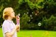 © Voyagerix - Man blowing soap bubbles outdoor