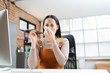 © torwaiphoto - Asian woman sneezes. She uses a tissue to cover her mouth and she is working at home.