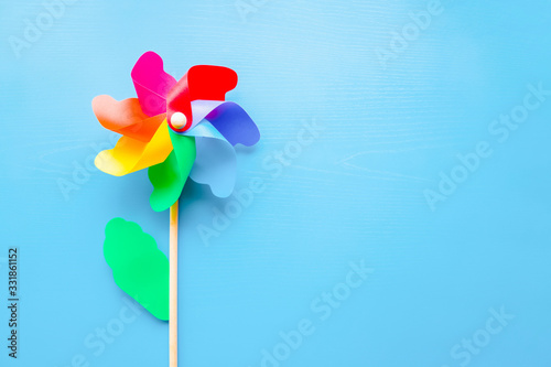 Cuadros en Lienzo Colorful plastic toy windmill propeller flower for kids on blue background