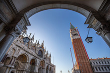 A View Of The Historic St. Marks Campanile Bell Tower And St. Marks Basilica, Located On Piazza San Marco In The City Of Venice In Italy.