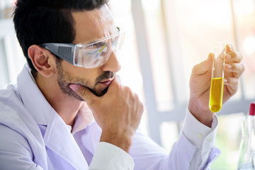 Wall Mural - attractive happiness scientist man lab technician assistant analyzing sample in test tube at laborat