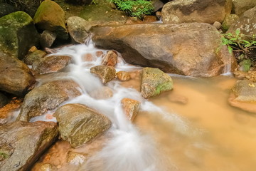 view of silky stream water flowing on arch rocks background, Pong Phra Bat Waterfall, Chiang Rai, northern of Thailand.