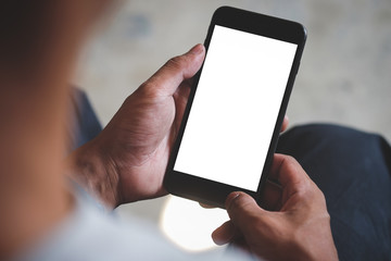 Cropped shot view of man hands holding smart phone with blank copy space screen for your text message or information content, female reading text message on cell telephone during in urban setting.