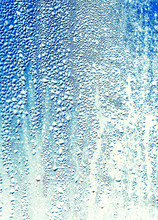 Drops Of Water On Blue Glass As An Abstract Background
