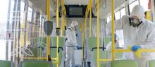 HazMat Team In Protective Suits Decontaminating Public Transport, Bus Interior During Virus Outbreak