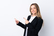 © luismolinero - Young business woman over isolated white background pointing finger to the side