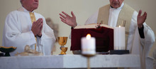 Two Priests Dressed In Liturgical Vestments Celebrate The Holy Mass In The  Roman Catholic Church. Worship At The Altar