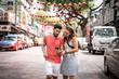 Couple looking at their mobile in the middle of the street decorated with red lanterns