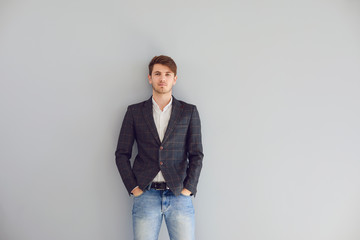 Young guy student in casual clothes standing looking up over gray background.