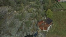Three Friends Standing On A Balcony At A Cabin On A Fjord In Norway, Drone Shot Revealing A Beautiful View