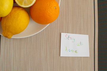 Stay at home. Concept of coronavirus quarantine. Oranges and lemons on a plate.