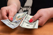 © Alena - Woman's hands counting hundred dollar bills over the table. selective focus