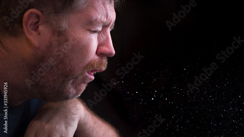 Fotografía A man sneezes and releases droplets in the air