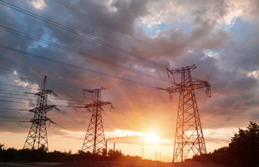 Wall Mural - a silhouette of high voltage power lines against a colorful sky at sunrise.