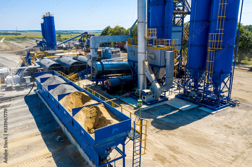 Equipment for production of asphalt, cement and concrete. Concrete plant. High tower of an asphalt plant. Harmful production. A mixture of bitumen and gravel, a mix machine. Aerial view. - obrazy, fototapety, plakaty 